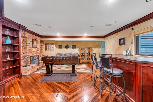 25 Canadian Woods Rd, Marlboro, NJ 07746 - playroom with wood finished floors, crown molding, a dry bar, and recessed lighting