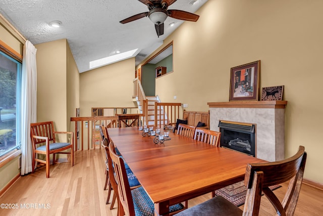 25 Canadian Woods Rd, Marlboro, NJ 07746 - dining area with ceiling fan, a skylight, a premium fireplace, light wood-type flooring, and lofted ceiling