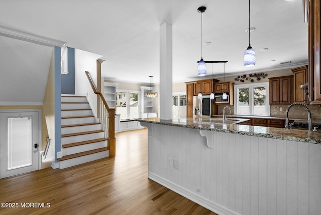58 Pinehurst Rd, Brick, NJ 08723 - kitchen featuring appliances with stainless steel finishes, stone counters, brown cabinets, wood finished floors, and ornamental molding