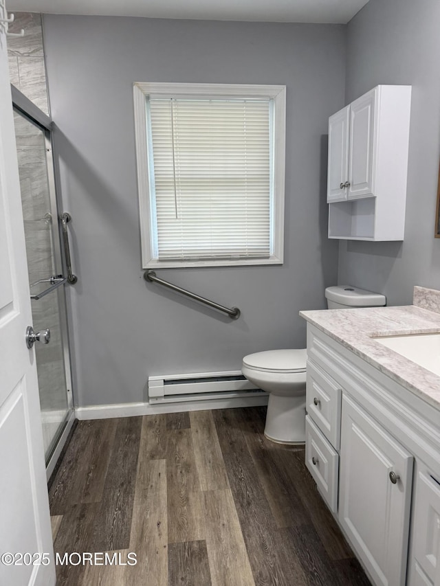 976 Aberdeen Dr Unit D, Lakewood, NJ 08701 - bathroom featuring a baseboard heating unit, a stall shower, vanity, and wood finished floors