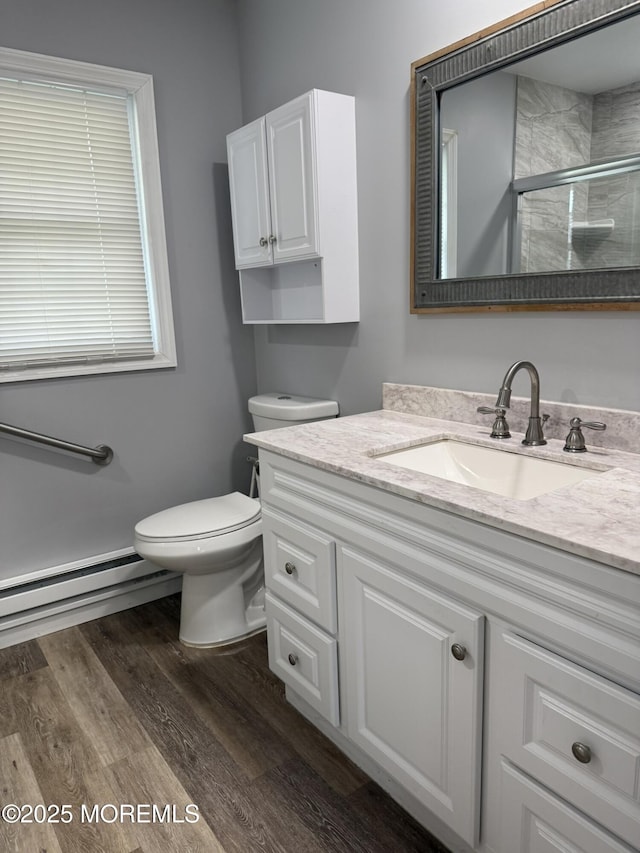 976 Aberdeen Dr Unit D, Lakewood, NJ 08701 - bathroom featuring a baseboard heating unit, a stall shower, vanity, and wood finished floors