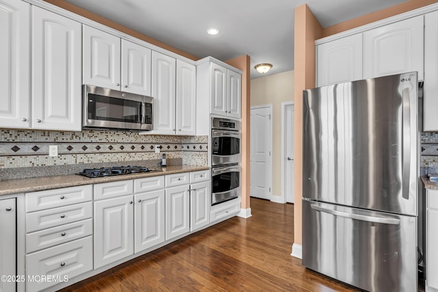42 Eagleswood Dr, Waretown, NJ 08758 - kitchen with stainless steel appliances, tasteful backsplash, white cabinets, dark wood finished floors, and recessed lighting