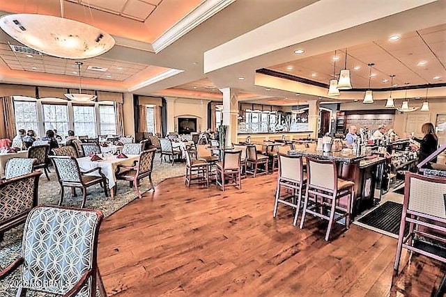 42 Eagleswood Dr, Waretown, NJ 08758 - dining area featuring a raised ceiling, wood finished floors, ornamental molding, and decorative columns