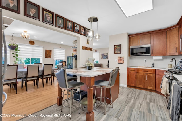 1D Daisy Ct, Lakewood, NJ 08701 - kitchen with stainless steel microwave, brown cabinetry, pendant lighting, a kitchen bar, and recessed lighting