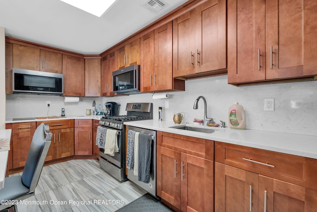 1D Daisy Ct, Lakewood, NJ 08701 - kitchen with appliances with stainless steel finishes, brown cabinets, light countertops, and decorative backsplash