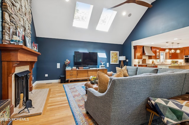 4040 Herbertsville Rd, Wall, NJ 08724 - living area featuring a fireplace, high vaulted ceiling, light wood finished floors, a skylight, and a ceiling fan
