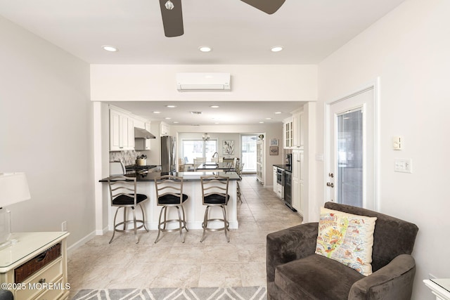 3 Newark Ave, Lavallette, NJ 08735 - kitchen featuring stainless steel fridge, a peninsula, a breakfast bar, ceiling fan, and under cabinet range hood