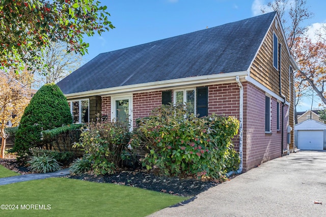 708 New York Blvd, Sea Girt, NJ 08750 - view of front of property with brick siding, roof with shingles, an outbuilding, and a detached garage