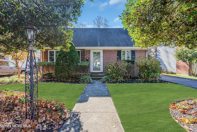 708 New York Blvd, Sea Girt, NJ 08750 - view of front of home featuring a front yard, brick siding, and a shingled roof
