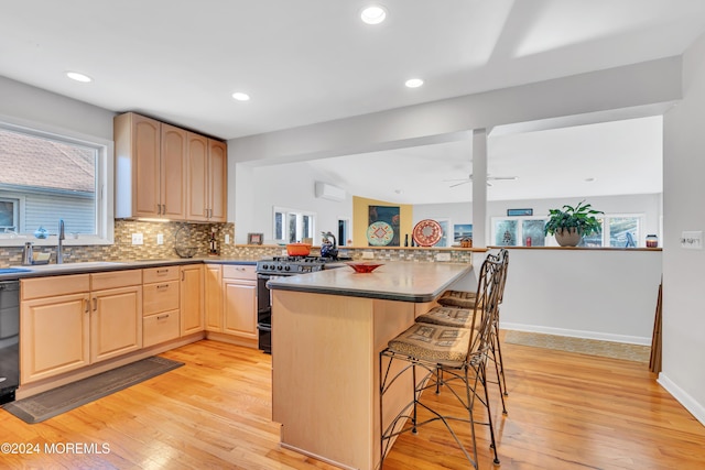 708 New York Blvd, Sea Girt, NJ 08750 - kitchen with gas range oven, light brown cabinetry, a breakfast bar, light wood finished floors, and recessed lighting
