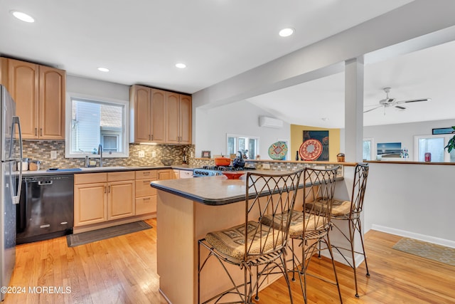 708 New York Blvd, Sea Girt, NJ 08750 - kitchen featuring black dishwasher, an AC wall unit, a kitchen breakfast bar, light brown cabinets, and light wood-type flooring