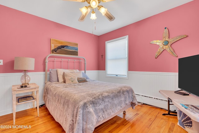 708 New York Blvd, Sea Girt, NJ 08750 - bedroom with wainscoting, a baseboard radiator, wood finished floors, and a ceiling fan