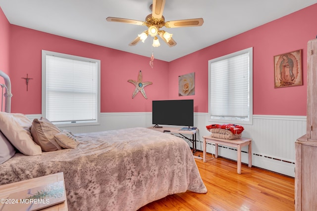 708 New York Blvd, Sea Girt, NJ 08750 - bedroom with wainscoting, wood finished floors, baseboard heating, and a ceiling fan