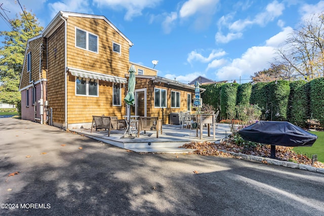 708 New York Blvd, Sea Girt, NJ 08750 - rear view of house with a wooden deck and outdoor dining area