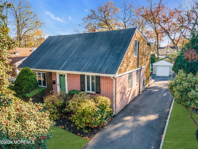 708 New York Blvd, Sea Girt, NJ 08750 - view of front of property with an outbuilding, a shingled roof, brick siding, a chimney, and a detached garage