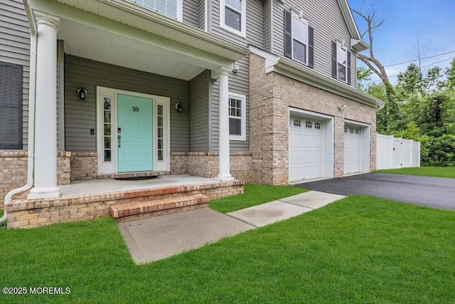 10 Willow Ave, Matawan, NJ 07747 - doorway to property with an attached garage, driveway, a yard, and covered porch