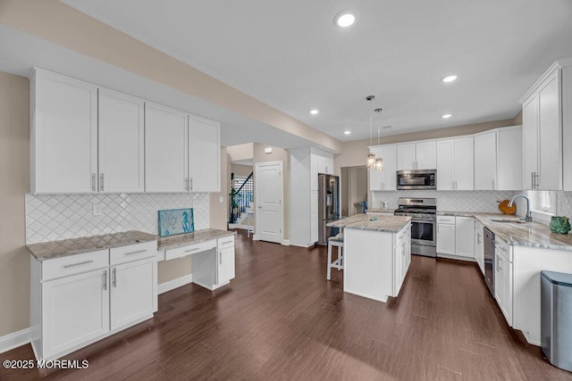 10 Willow Ave, Matawan, NJ 07747 - kitchen with stainless steel appliances, backsplash, white cabinetry, a kitchen bar, and recessed lighting