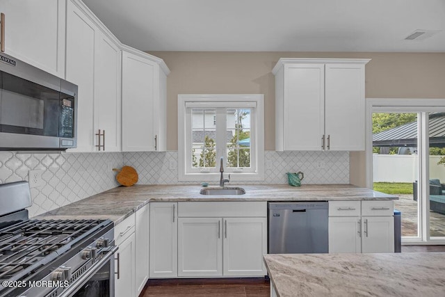 10 Willow Ave, Matawan, NJ 07747 - kitchen featuring stainless steel appliances, white cabinetry, light stone counters, and backsplash