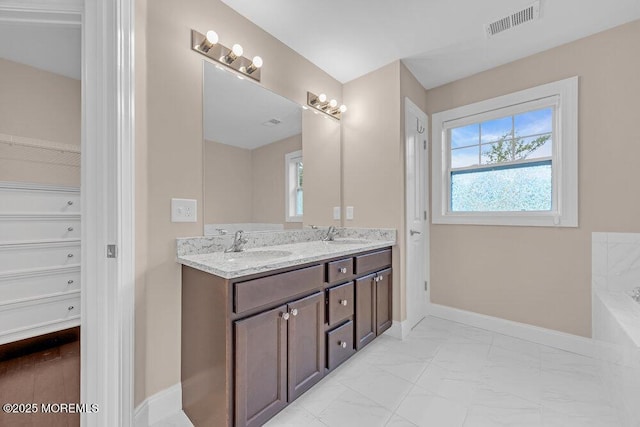 10 Willow Ave, Matawan, NJ 07747 - full bath with double vanity, healthy amount of natural light, marble finish flooring, and a tub to relax in