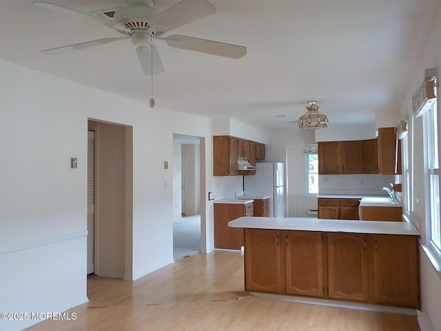 17 Meadowbrook Rd, Brick, NJ 08723 - kitchen featuring freestanding refrigerator, under cabinet range hood, light countertops, brown cabinets, and a peninsula
