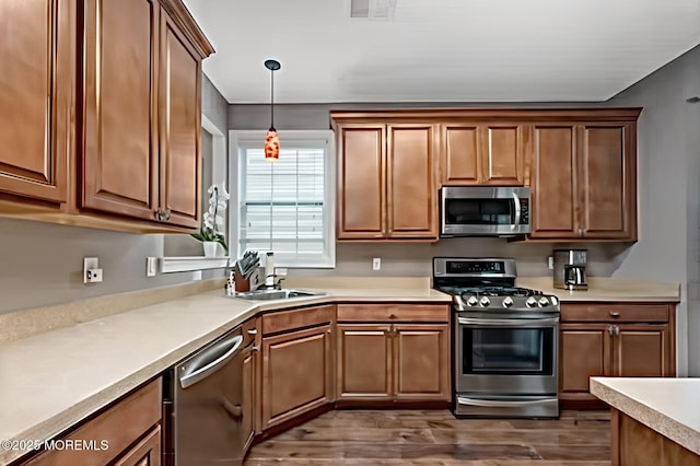 114 Maypink Ln, Howell, NJ 07731 - kitchen featuring stainless steel appliances, dark wood-style flooring, light countertops, pendant lighting, and brown cabinetry