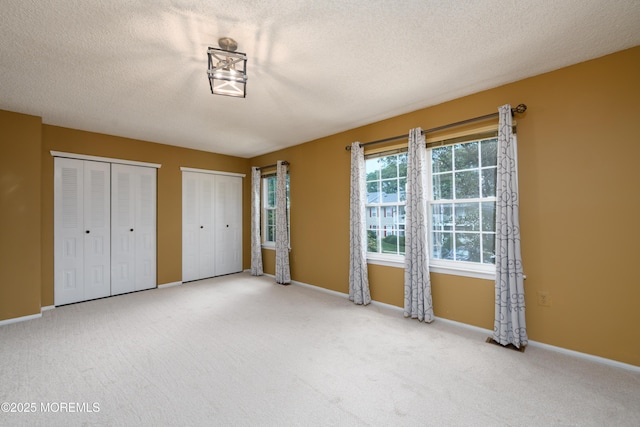 60 Beaumont Ct, Tinton Falls, NJ 07724 - unfurnished bedroom with two closets, carpet, and a textured ceiling