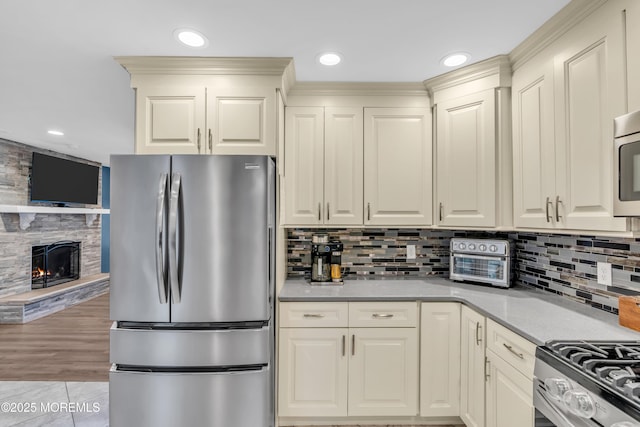 217 Hemlock Dr, Lanoka Harbor, NJ 08734 - kitchen featuring stainless steel appliances, light countertops, tasteful backsplash, a fireplace, and recessed lighting