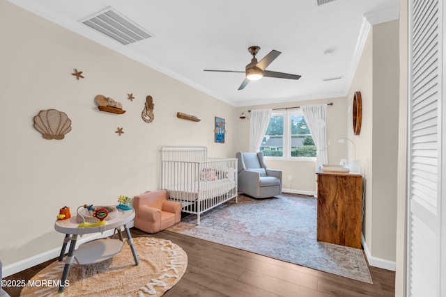 217 Hemlock Dr, Lanoka Harbor, NJ 08734 - bedroom with crown molding, a nursery area, wood finished floors, and a ceiling fan
