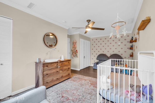 217 Hemlock Dr, Lanoka Harbor, NJ 08734 - bedroom featuring ornamental molding, wood finished floors, a nursery area, wallpapered walls, and a ceiling fan