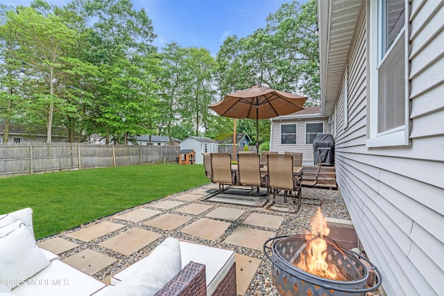 217 Hemlock Dr, Lanoka Harbor, NJ 08734 - fenced backyard with a fire pit, a storage shed, outdoor dining space, a patio area, and area for grilling