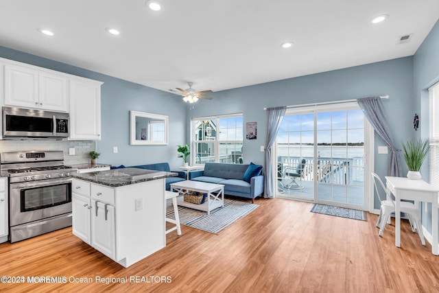 681/2 Shrewsbury Ave, Highlands, NJ 07732 - kitchen with stainless steel appliances, light wood-type flooring, dark stone countertops, white cabinetry, and a breakfast bar