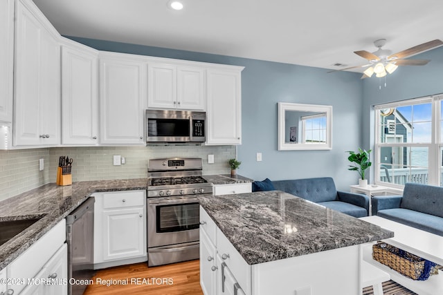681/2 Shrewsbury Ave, Highlands, NJ 07732 - kitchen featuring stainless steel appliances, tasteful backsplash, white cabinets, ceiling fan, and dark stone counters