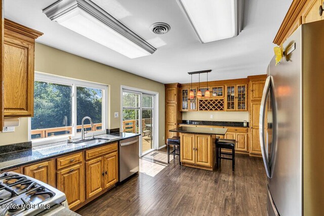 22 Indian Hill Rd, Freehold, NJ 07728 - kitchen with stainless steel appliances, a breakfast bar area, brown cabinets, and dark wood finished floors