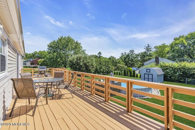 22 Indian Hill Rd, Freehold, NJ 07728 - wooden deck with a storage shed, outdoor dining area, and view of scattered trees