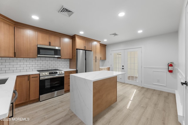 164 Cours De Clemenceau Unit E, Freehold, NJ 07728 - kitchen featuring stainless steel appliances, french doors, brown cabinetry, light wood-style flooring, and recessed lighting