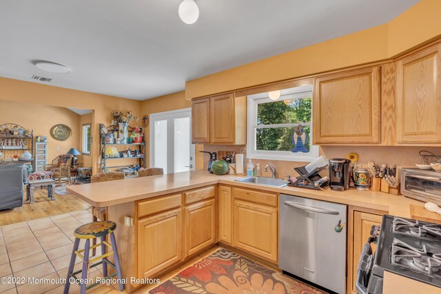 716 Hyson Rd, Jackson, NJ 08527 - kitchen with dishwasher, gas stove, a peninsula, light countertops, and a kitchen bar