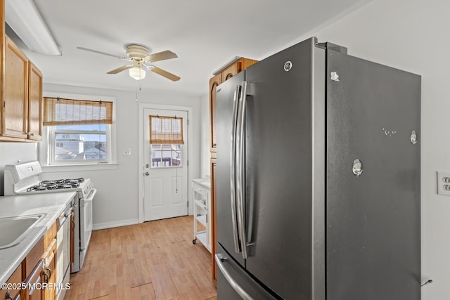 118 Sampson Ave, Seaside Heights, NJ 08751 - kitchen with freestanding refrigerator, white gas stove, ceiling fan, light wood-style flooring, and light countertops