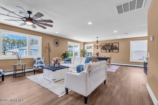 3 Andover Ct, Toms River, NJ 08757 - living room featuring a baseboard heating unit, light wood-type flooring, healthy amount of natural light, recessed lighting, and a chandelier