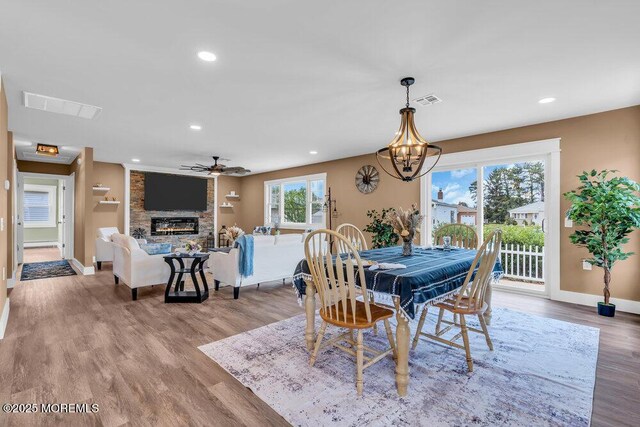 3 Andover Ct, Toms River, NJ 08757 - dining room with a stone fireplace, wood finished floors, a chandelier, ceiling fan, and recessed lighting