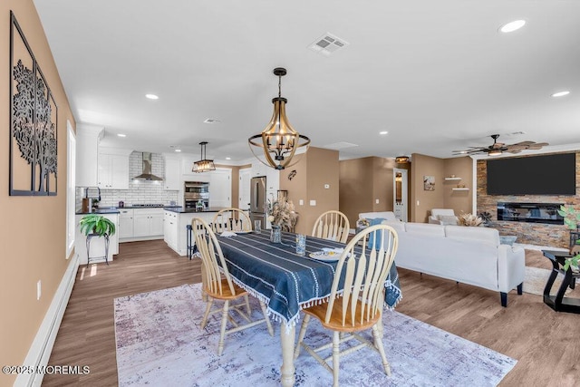 3 Andover Ct, Toms River, NJ 08757 - dining area featuring a ceiling fan, wood finished floors, recessed lighting, a chandelier, and a stone fireplace