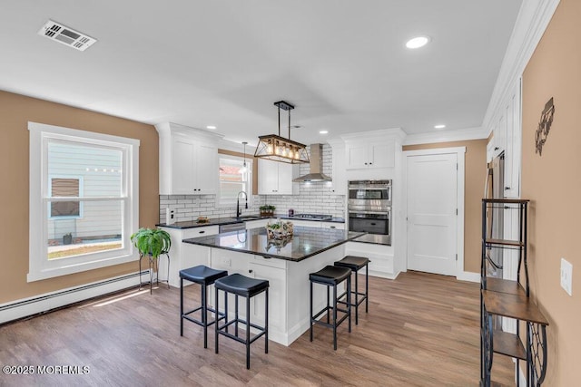 3 Andover Ct, Toms River, NJ 08757 - kitchen featuring appliances with stainless steel finishes, dark countertops, a kitchen bar, wall chimney exhaust hood, and tasteful backsplash