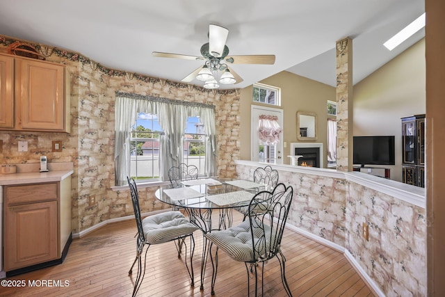 28 Brent Dr, Howell, NJ 07731 - dining room with light wood-style flooring, a ceiling fan, a lit fireplace, and lofted ceiling