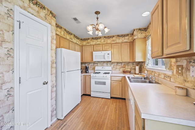 28 Brent Dr, Howell, NJ 07731 - kitchen with white appliances, a chandelier, light countertops, light wood-style floors, and backsplash
