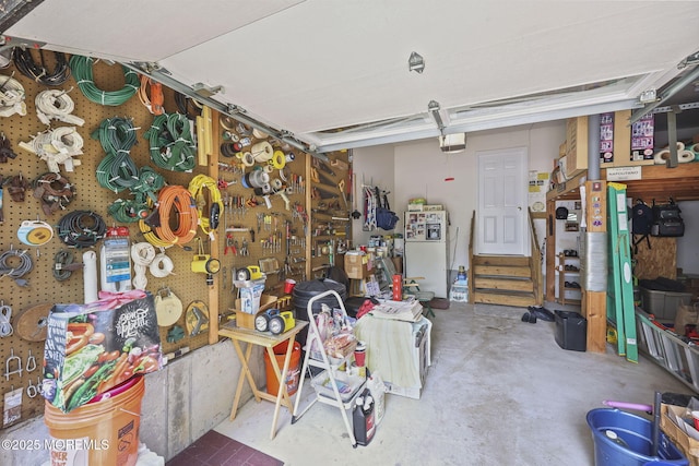 28 Brent Dr, Howell, NJ 07731 - garage with freestanding refrigerator, a garage door opener, and a workshop area