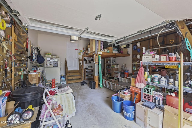 28 Brent Dr, Howell, NJ 07731 - garage with a garage door opener, freestanding refrigerator, and a workshop area
