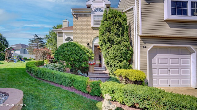 44 Kentucky Way, Freehold, NJ 07728 - view of front facade with a front lawn, an attached garage, brick siding, a playground, and a chimney