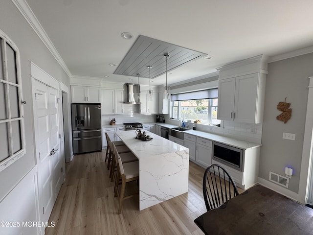 1464 Earie Way, Forked River, NJ 08731 - kitchen featuring stainless steel appliances, wall chimney range hood, a kitchen island, decorative backsplash, and ornamental molding