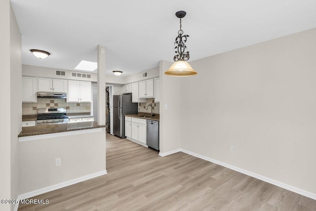 63 Oak Ln, Eatontown, NJ 07724 - kitchen featuring stainless steel appliances, under cabinet range hood, decorative backsplash, and white cabinetry