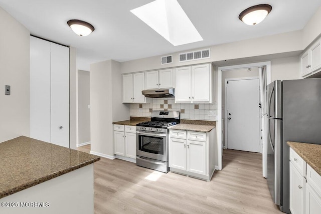 63 Oak Ln, Eatontown, NJ 07724 - kitchen featuring stainless steel appliances, under cabinet range hood, a skylight, light wood-type flooring, and tasteful backsplash