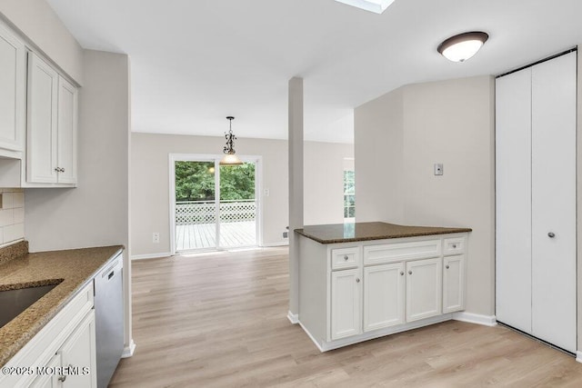 63 Oak Ln, Eatontown, NJ 07724 - kitchen with stainless steel dishwasher, light wood finished floors, dark stone countertops, and white cabinets